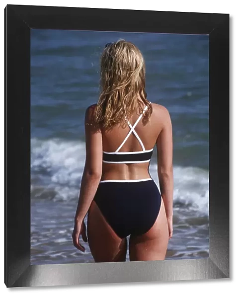 Back shot of a young woman in a bikini outdoors