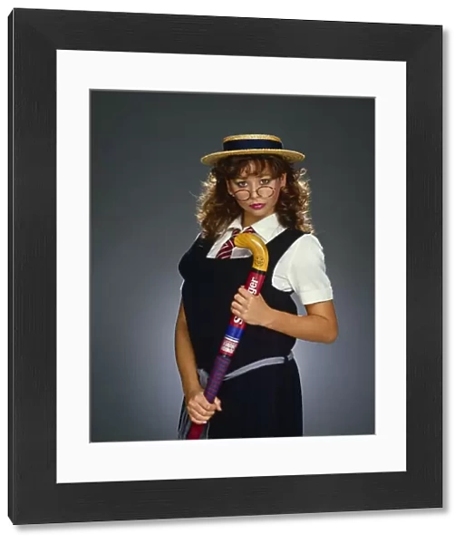 Maria Whittaker, dressed as schoolgirl, holding a hockey stick