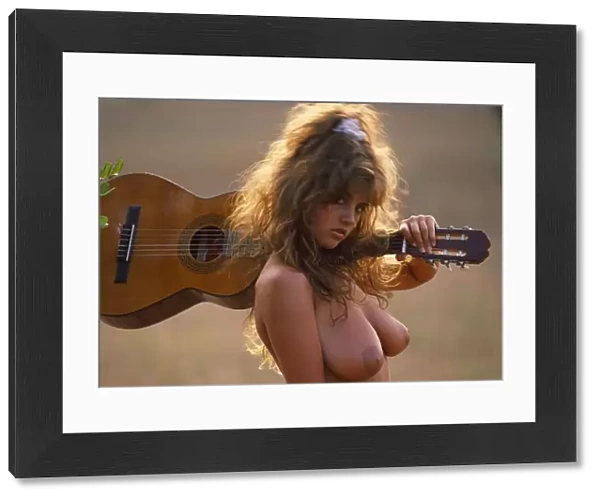 Gail McKenna, topless, outdoors with guitar