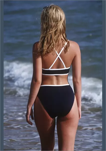 Back shot of a young woman in a bikini outdoors