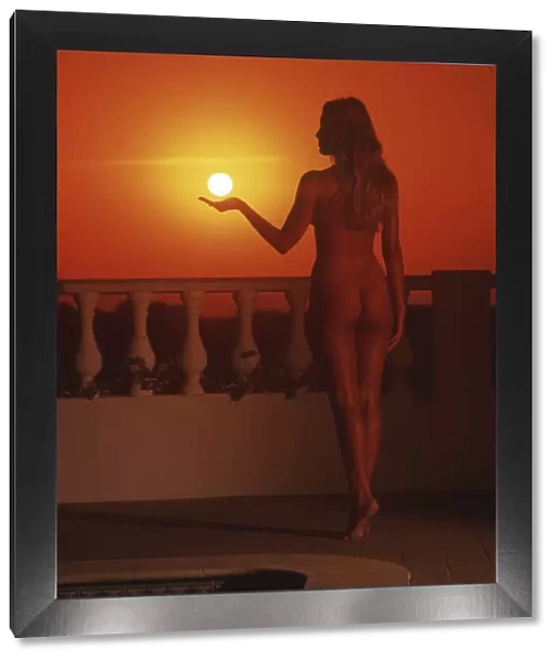Back shot of a nude girl at sunset