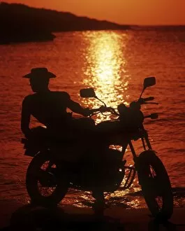 Male Collection: Hunk in profile on a motorbike at sunset
