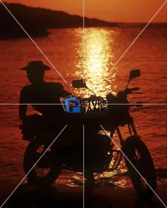 Orange Gallery: Hunk in profile on a motorbike at sunset