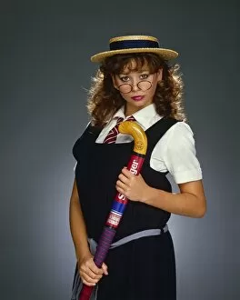 Indoors Collection: Maria Whittaker, dressed as schoolgirl, holding a hockey stick